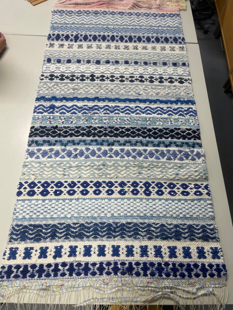 Taru Hakasen kutoma sinivalkosävyinen matto