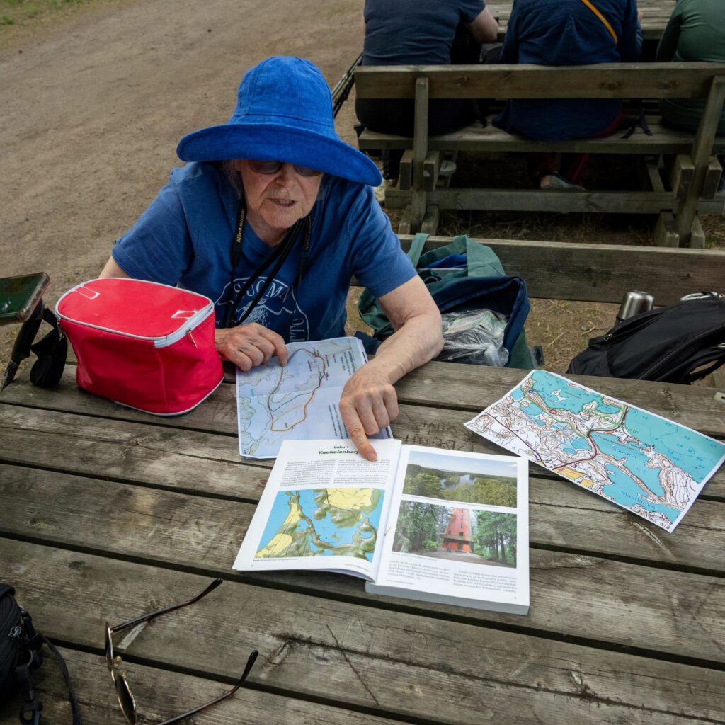 Alueen kartan tutkimista pirtinpöydän ääressä.