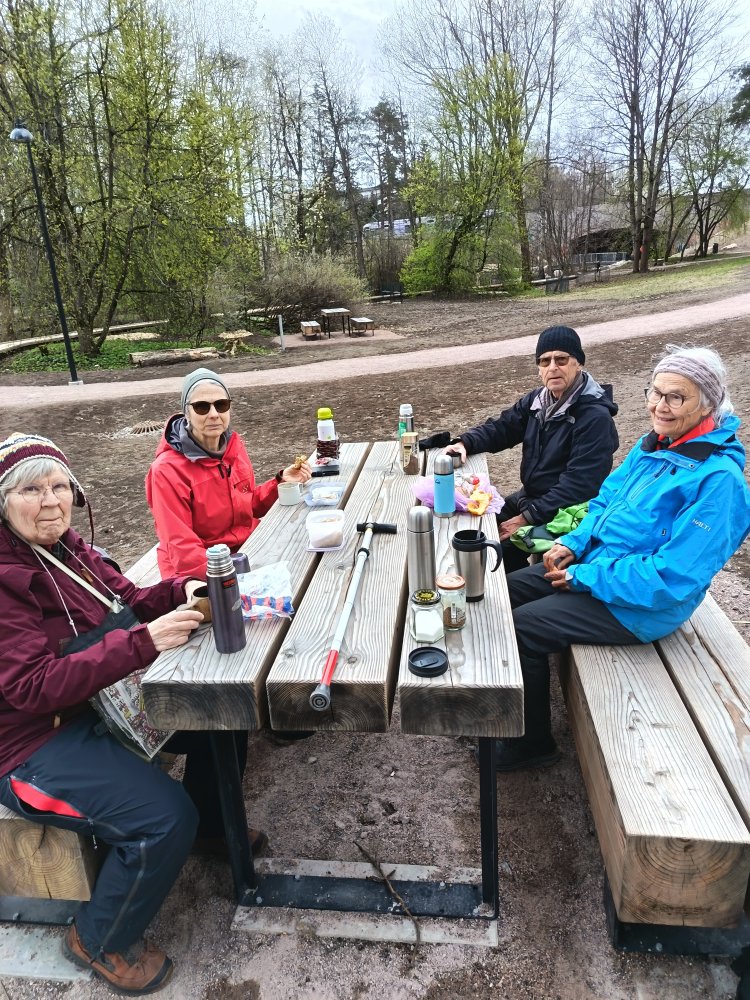 Människor runt ett bord utomhus.