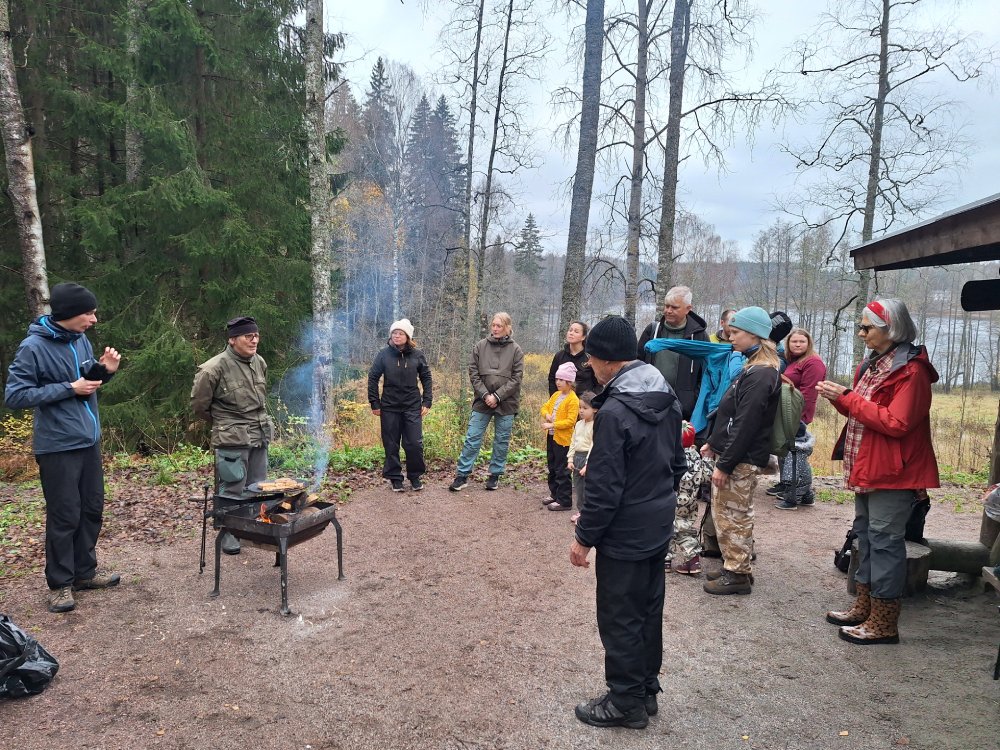 Människor står i ring och lyssnar på instruktioner.