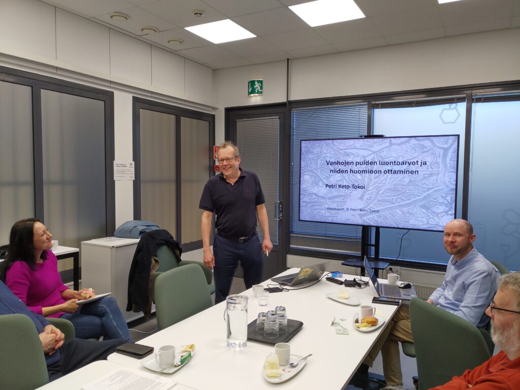 Esitelmän pitäjä ja yleisö nauravat.