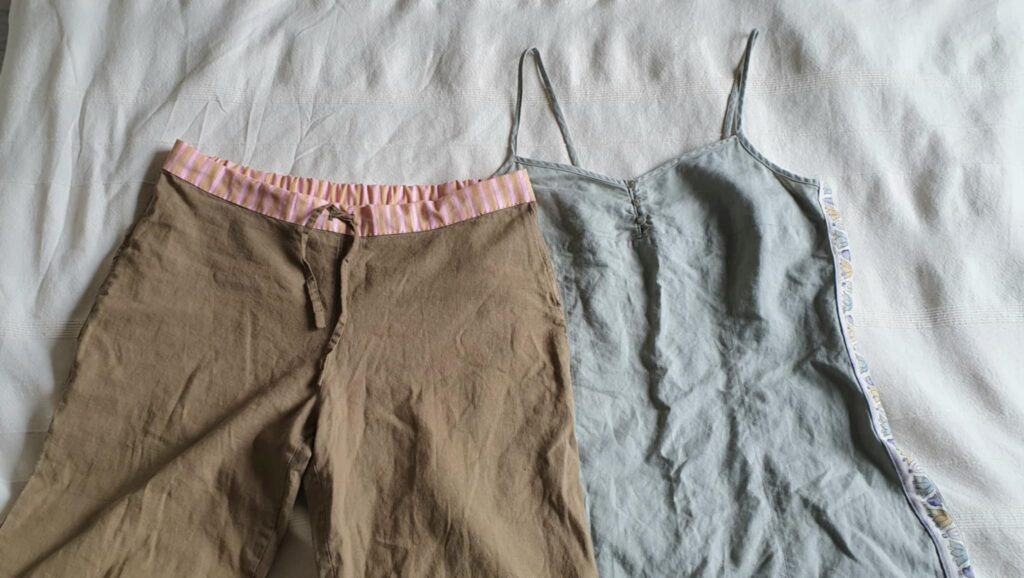 Pellavaiset housut, joihin on tehty uusi vy&ouml;t&auml;r&ouml; raitakankaasta ja pellavainen mekko, johon on tehty sivusaumoihin koristeellisesta kankaasta levennys