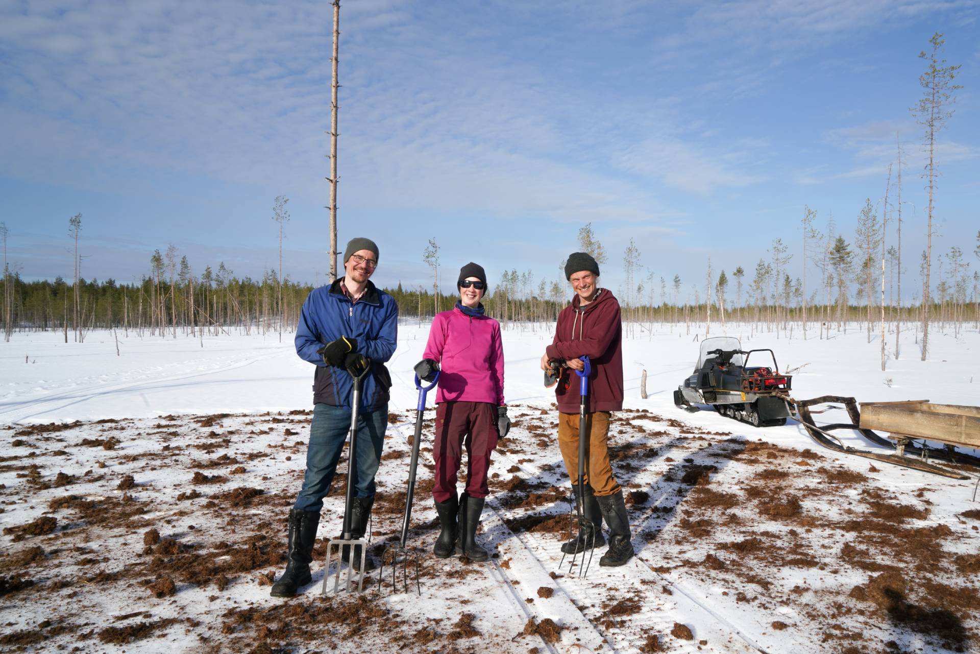 Kolme luonnonsuojelijaa talikot kädessä ennallistettavalla Isolla Piitsonsuolla.