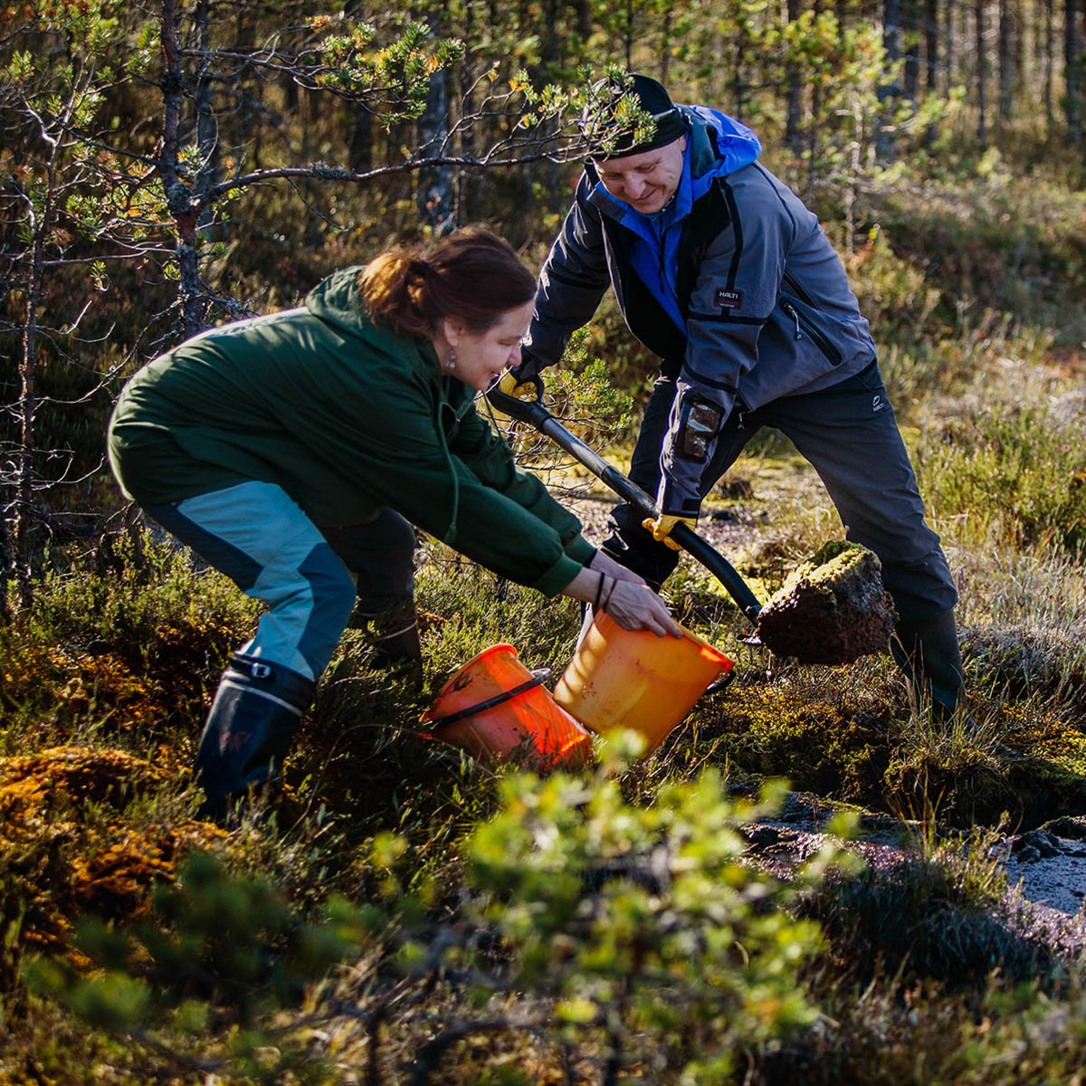 Kaksi ihmistä ennallistaa Savansuota.