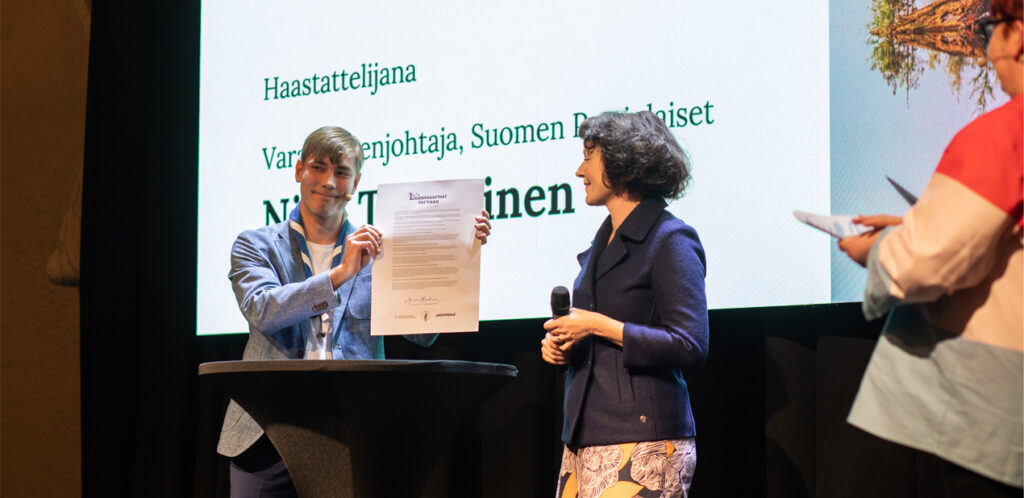 Jenni Haukio allekirjoittaa vetoomuksen Luontoaarteet turvaan -julkistustilaisuuden lavalla.