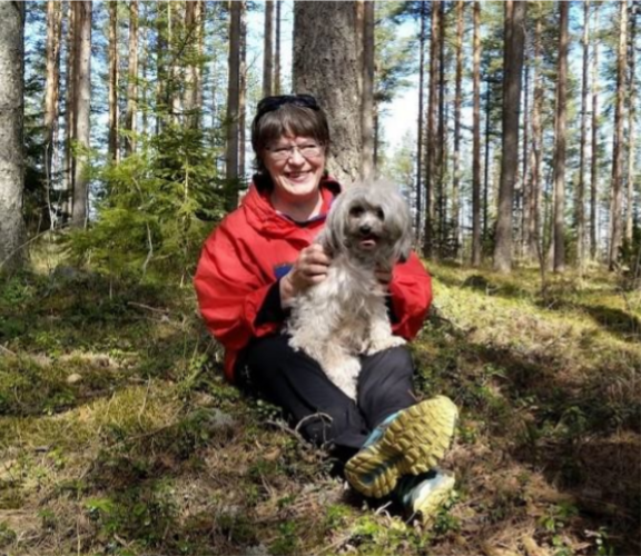 Anne Laine metsässä koiransa kanssa.